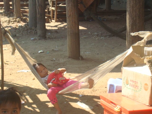 A photo of a small girl sleeping in a hammock in Kompong Phluk, Cambodia