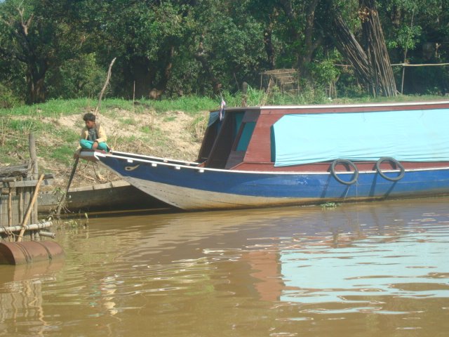 A photo of a child sitting on a medium sized boat