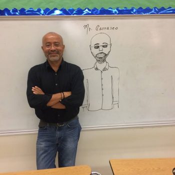 Jose in front of a student-drawn caricature while teaching in Miami