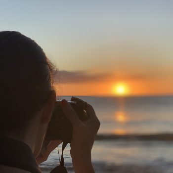 Leesa taking a photo of a beach sunset