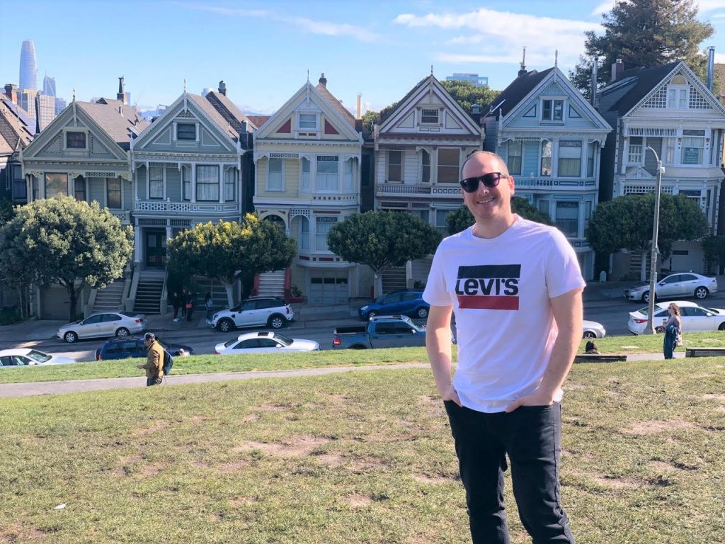 An image of Moshe standing outside the famous San Francisco Houses
