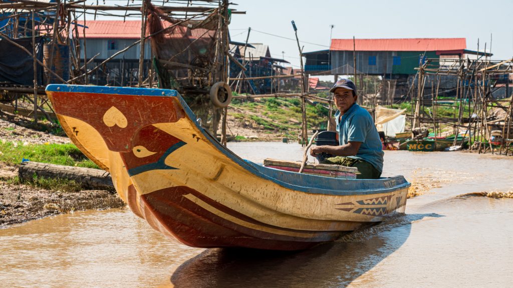 A photo of a villager rowing a canoe in Kompong Phluk, Cambodia.