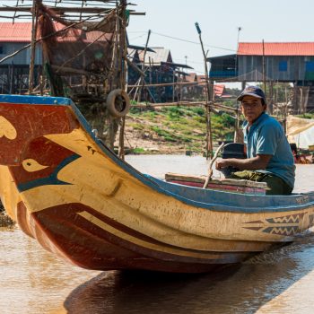 A photo of a villager rowing a canoe in Kompong Phluk, Cambodia.