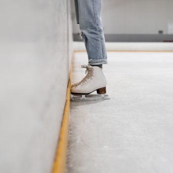 Photo by Kelli McClintock. An ice skater hugging the wall on an ice rink